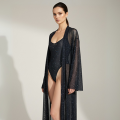 Model wearing a black sheer robe over a matching outfit on a plain background