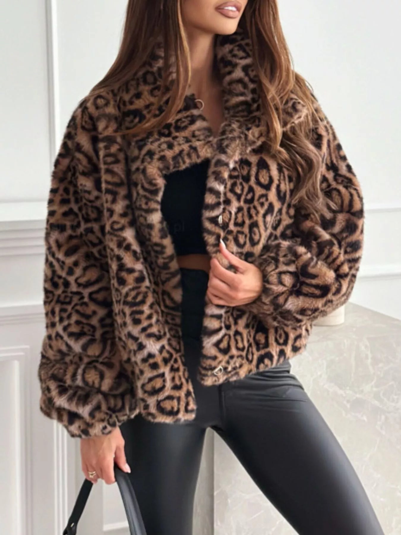 Person wearing a leopard print coat with a neutral background