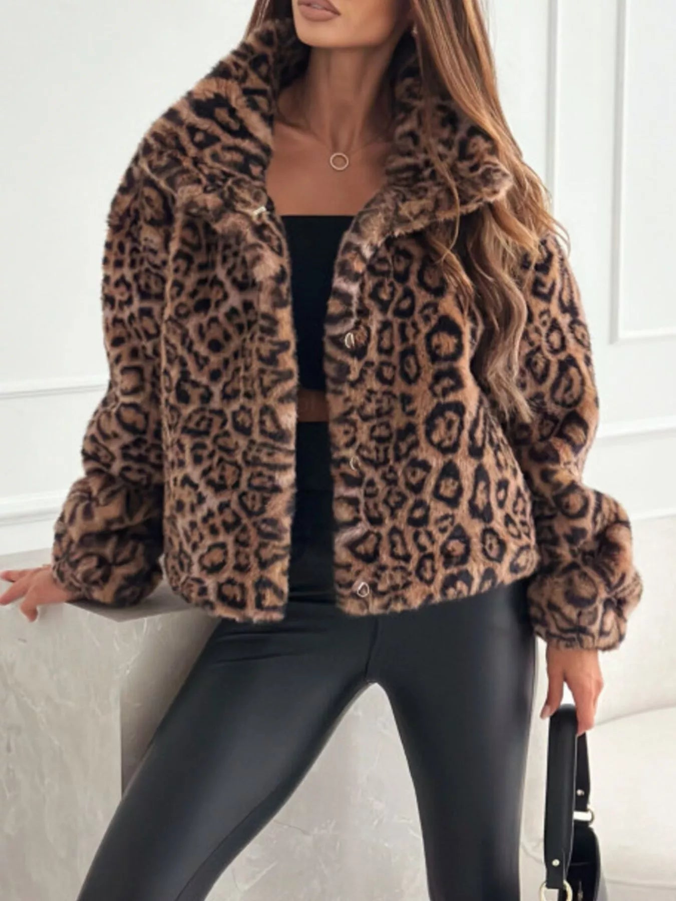 Person wearing a leopard print coat with a neutral background