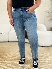 Person wearing blue jeans and black sneakers on a neutral background