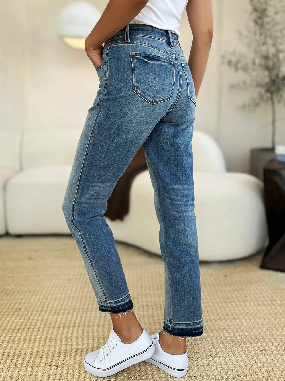 Person wearing blue jeans and white sneakers in a casual setting
