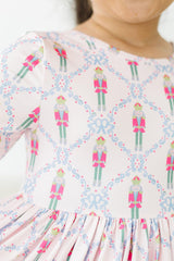 Close-up of a dress with a pattern of colorful characters and flowers on a white background.