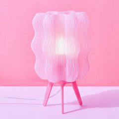 Pink table lamp with wavy design on a pink background