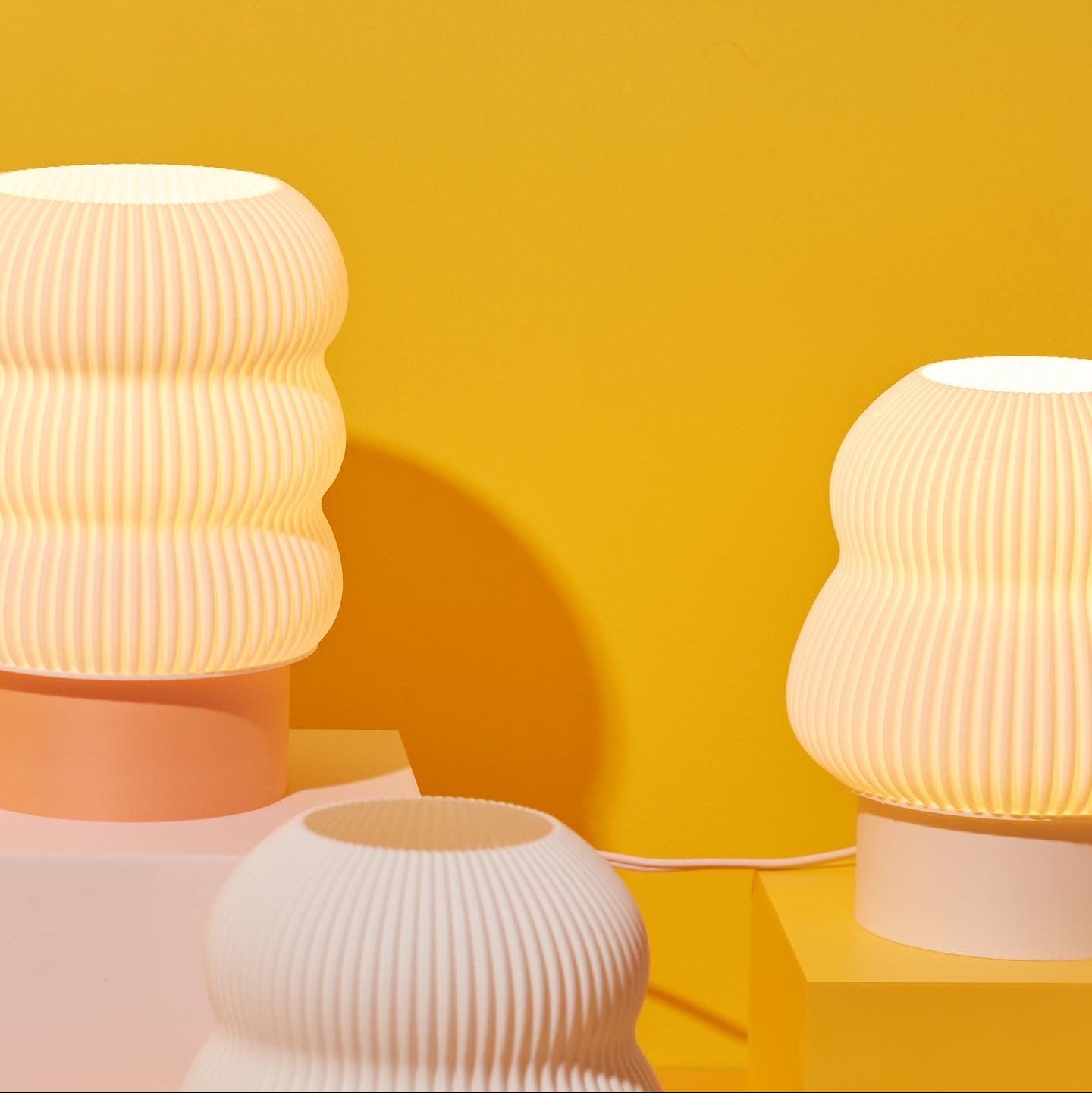 Three textured lamps on a yellow background