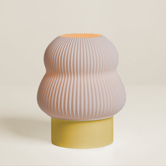 Decorative vase with ribbed design and yellow base on a beige background