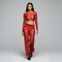 Model wearing a red lace outfit on a gray background