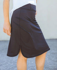 Person wearing a black skirt with a plain background