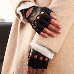 Person wearing black leather gloves with a beige coat