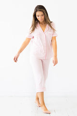 Woman wearing pink pajamas on a white background
