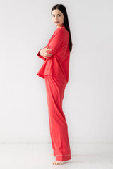 Woman wearing a red pajama set against a white background