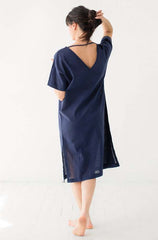 Woman wearing a navy blue dress with mesh panels on a white background