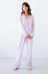 Woman wearing lavender pajamas on a white background