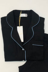 Black pajama set with white piping on a white background