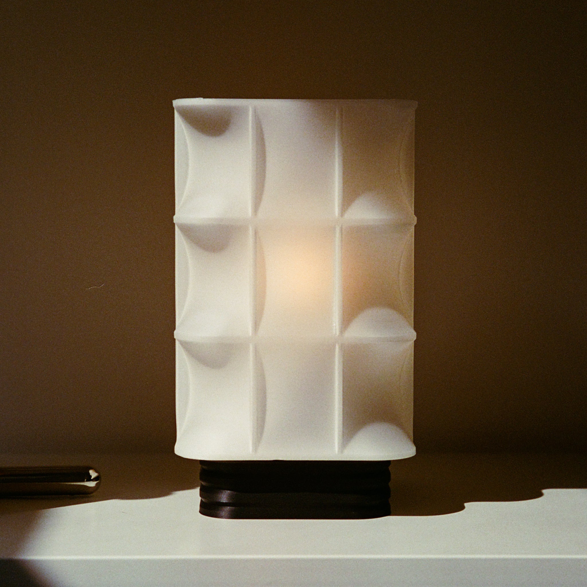 White textured table lamp on a dark background