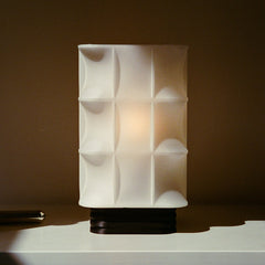 White textured table lamp on a dark background