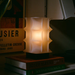 Decorative lamp on a stack of books with a dark background