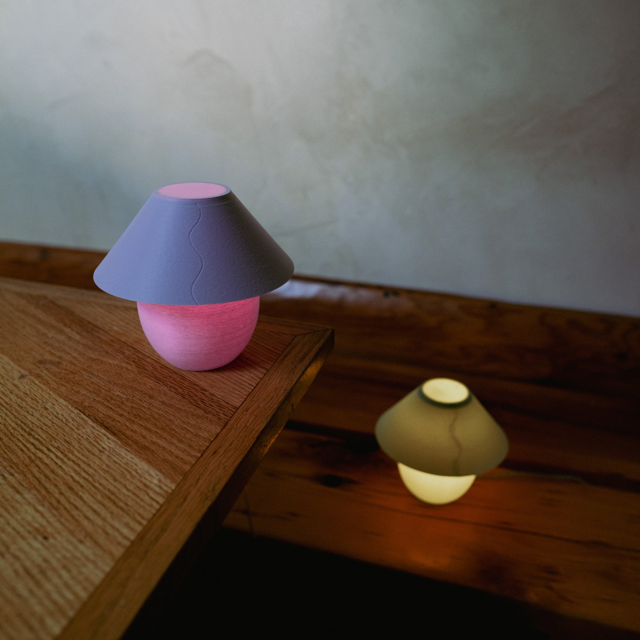 Two colorful night lights on wooden surfaces with a neutral background