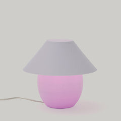 Table lamp with a pink base and gray shade on a light gray background