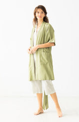 Woman wearing a green kimono-style outfit on a white background