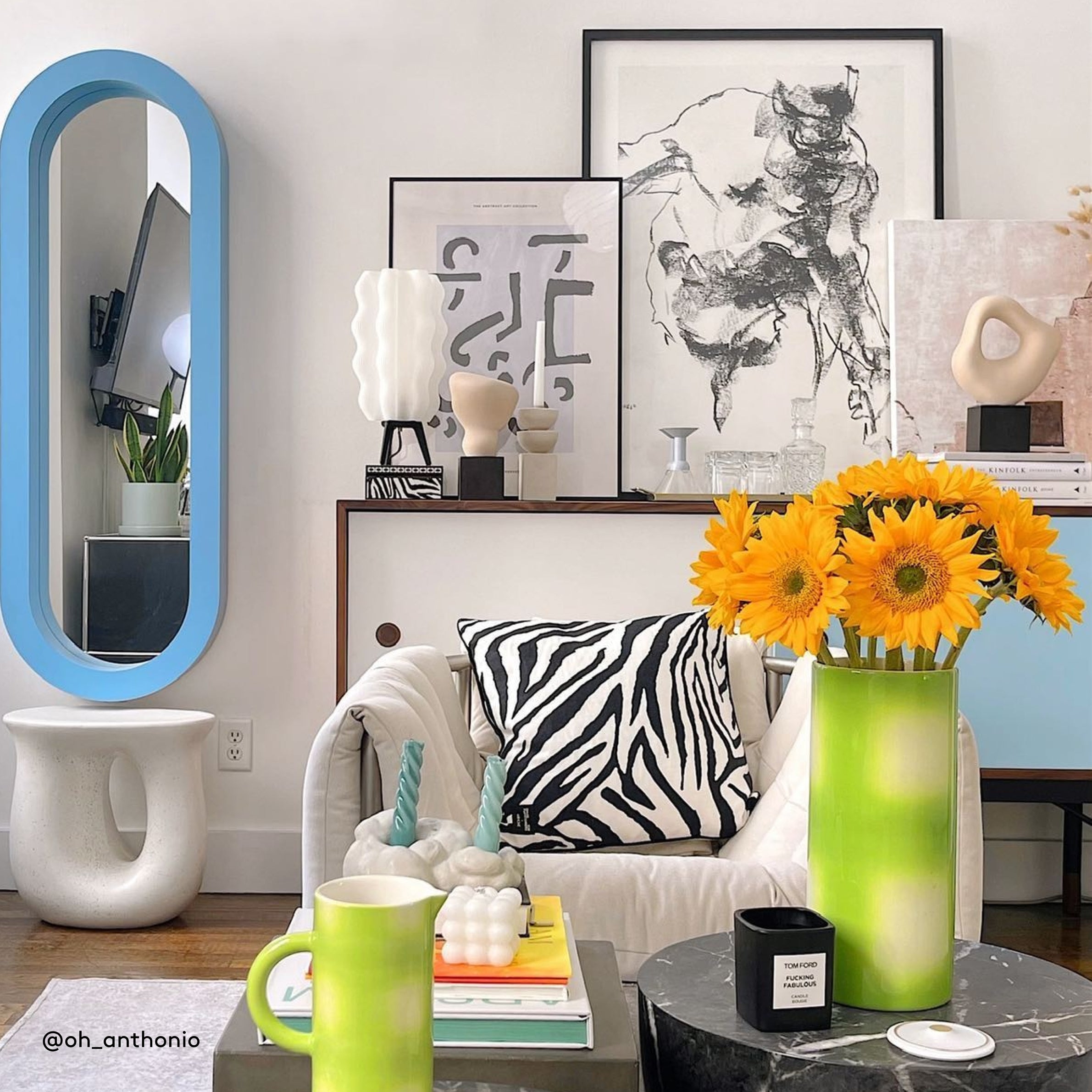 Modern living room with a zebra-patterned pillow, colorful decor, and a vase with yellow flowers.