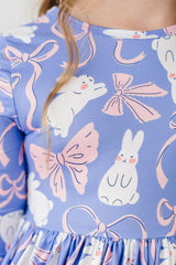 Close-up of a dress with bunny and bow pattern on a blue background