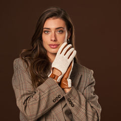 Woman wearing a plaid coat and brown leather gloves against a brown background