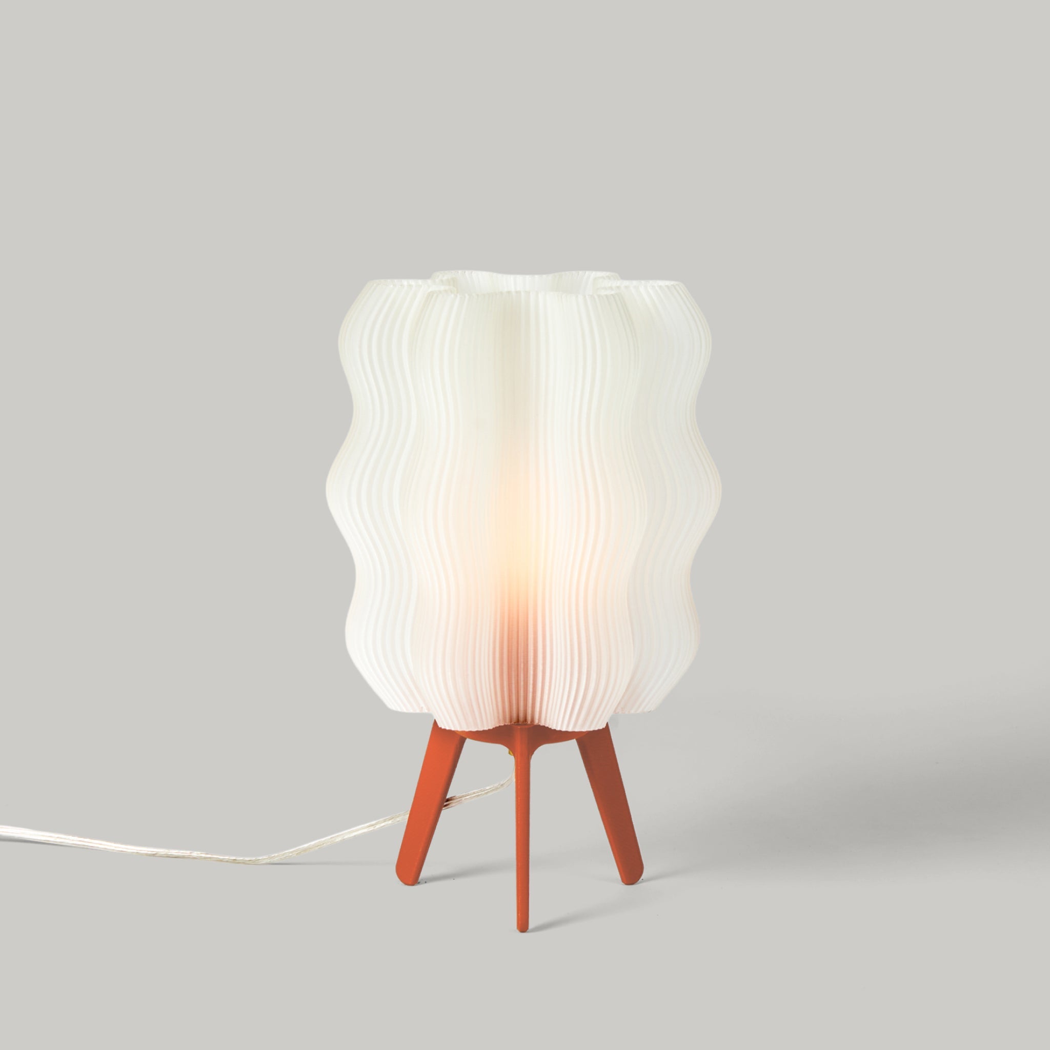 Table lamp with a textured white shade and wooden base on a gray background