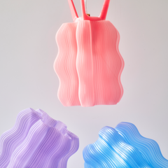 Pink, purple, and blue wavy silicone products on a light gray background