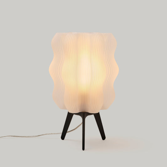 Table lamp with wavy glass shade on a plain background