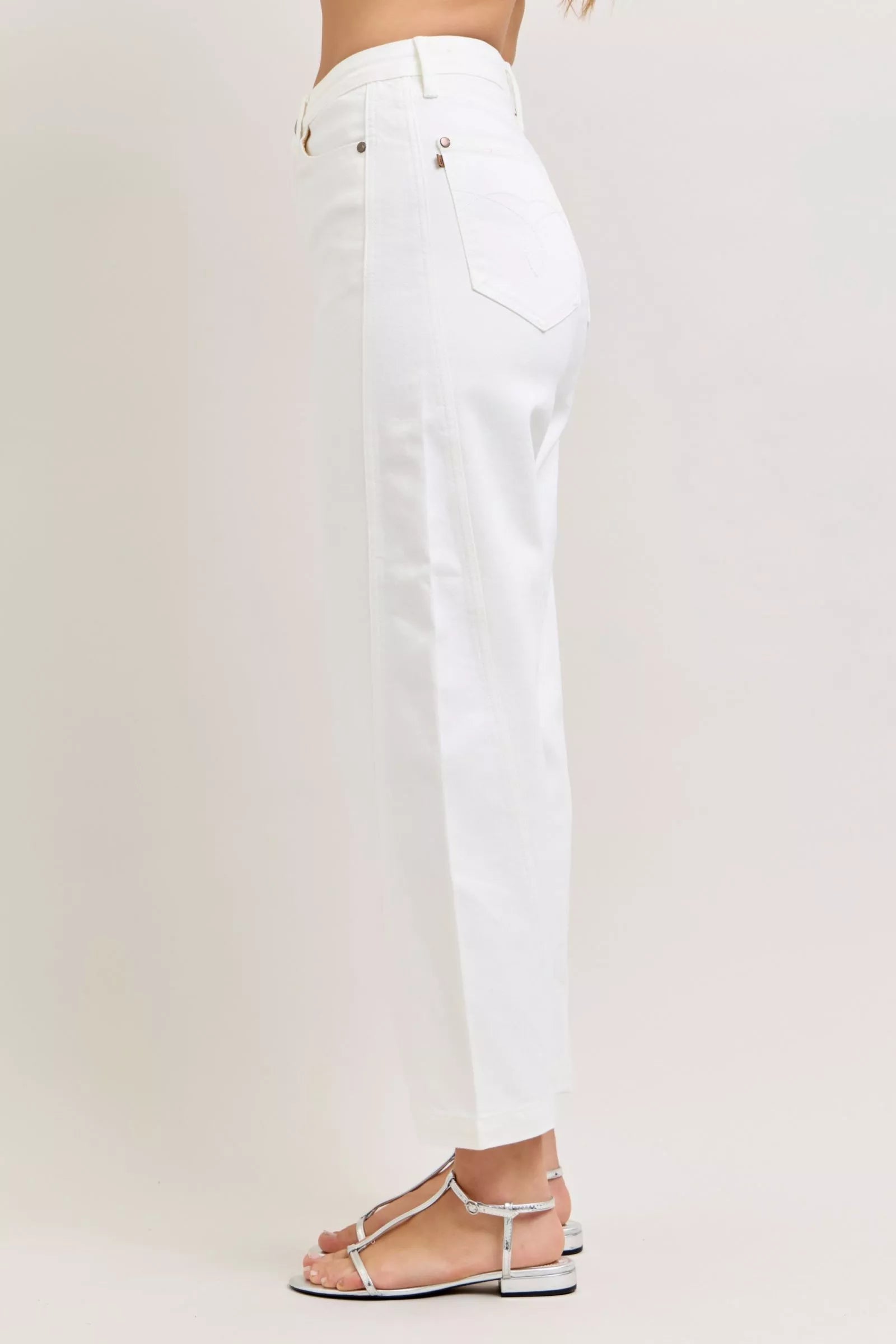 White pants worn by a person on a white background