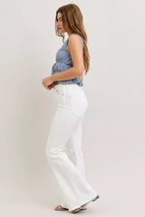 Woman wearing a blue checkered top and white pants on a plain background