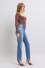Woman wearing a brown top and blue jeans on a white background