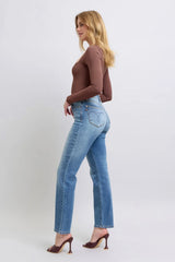 Woman wearing blue jeans and a brown top on a white background