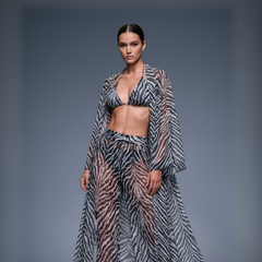 Model wearing a zebra print outfit on a gray background