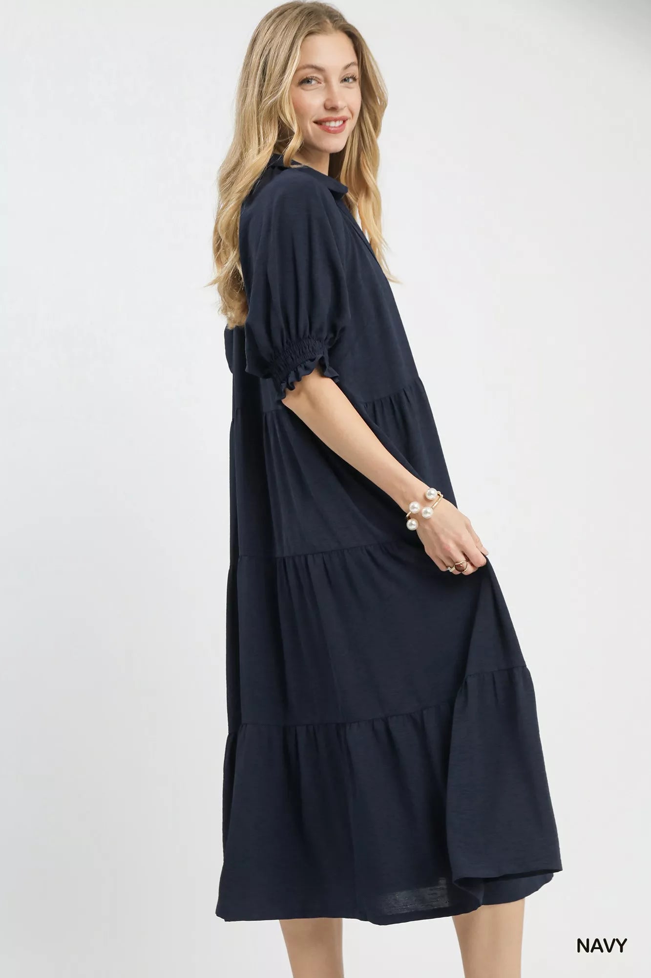 Woman wearing a navy dress on a white background
