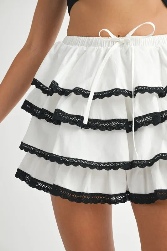 White shorts with black lace trim on a white background