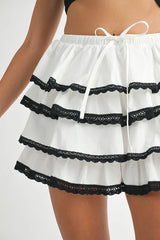 White shorts with black lace trim on a white background