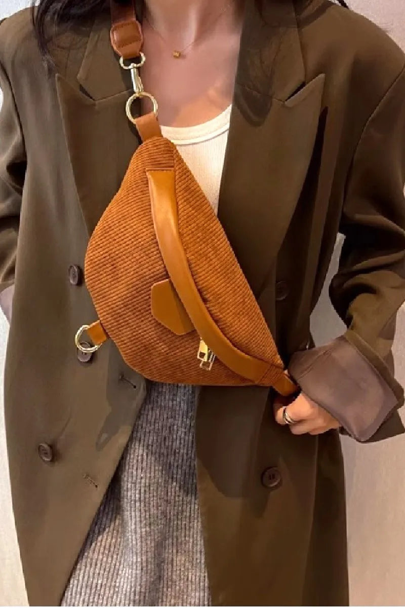 Person wearing a brown textured bag over one shoulder, with a neutral background