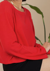 Person wearing a red sweater with a blurred background