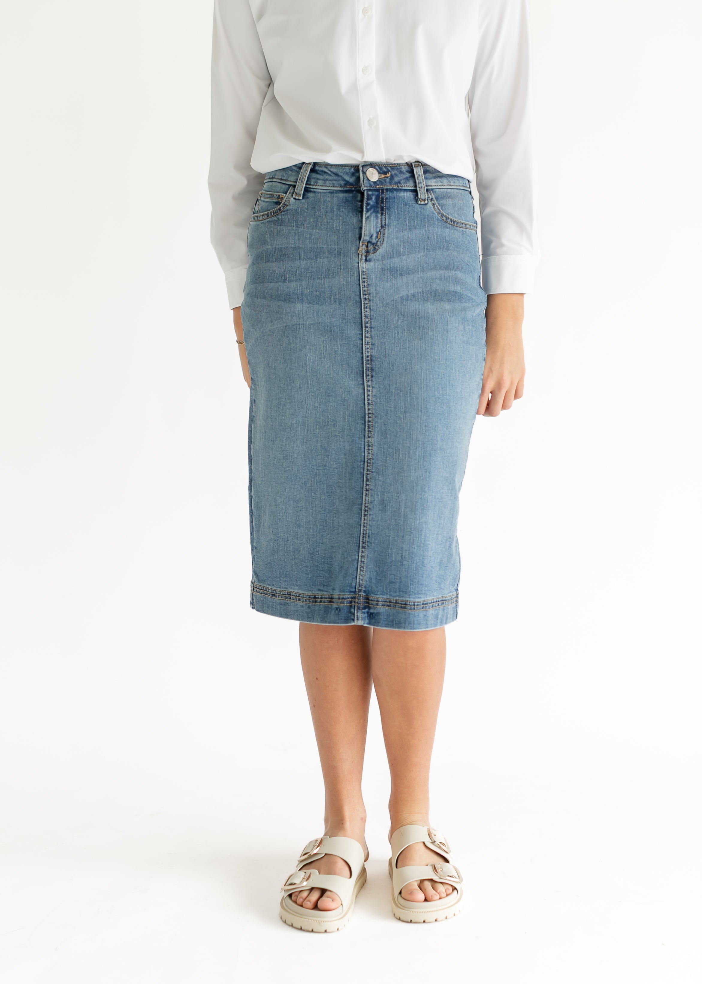 Person wearing a light blue denim skirt on a white background