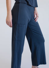 Navy blue pants worn by a person on a plain background