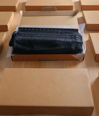 Black fabric in a cardboard box on a wooden surface