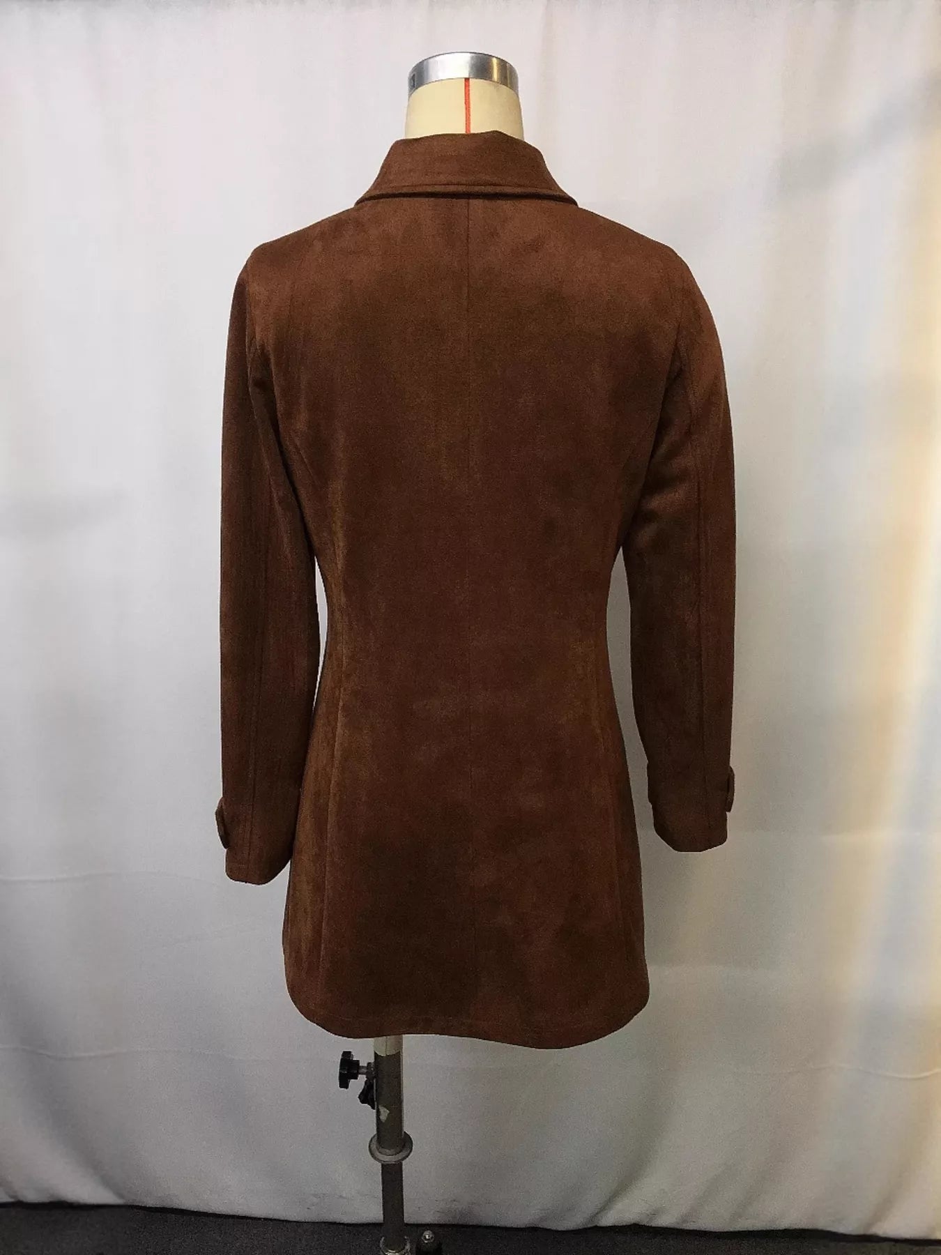 Brown suede coat on a mannequin against a white background