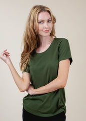 Woman wearing a green t-shirt against a beige background