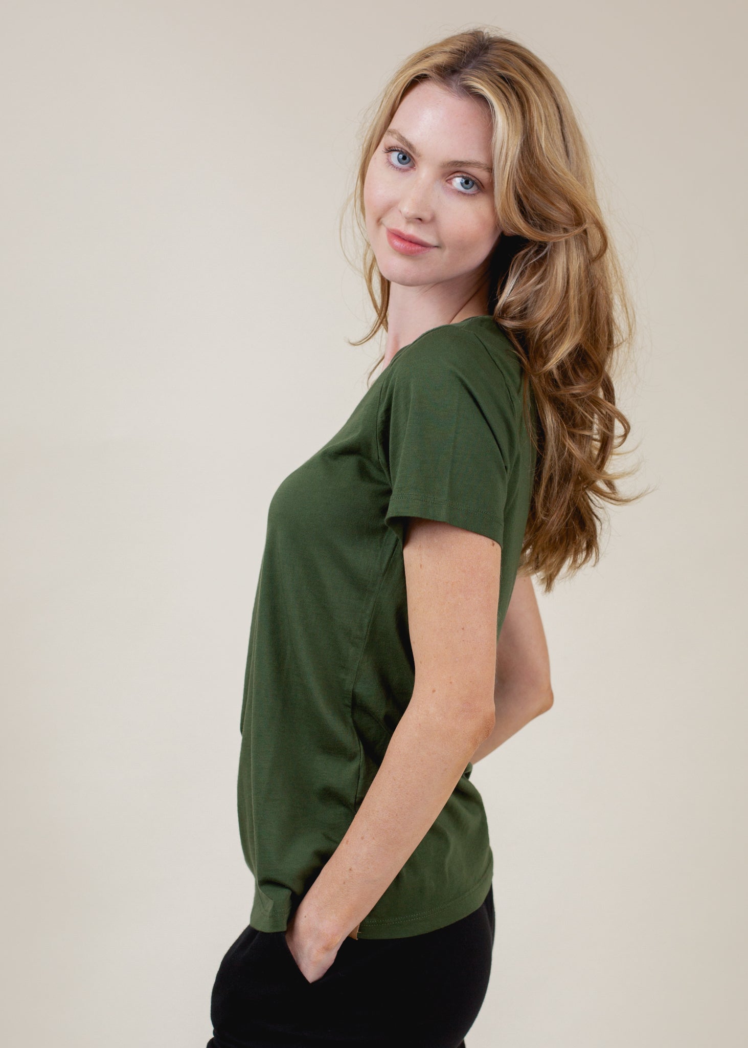 Woman wearing a green top against a plain background