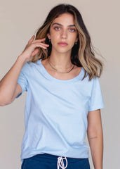 Woman wearing a light blue t-shirt against a neutral background