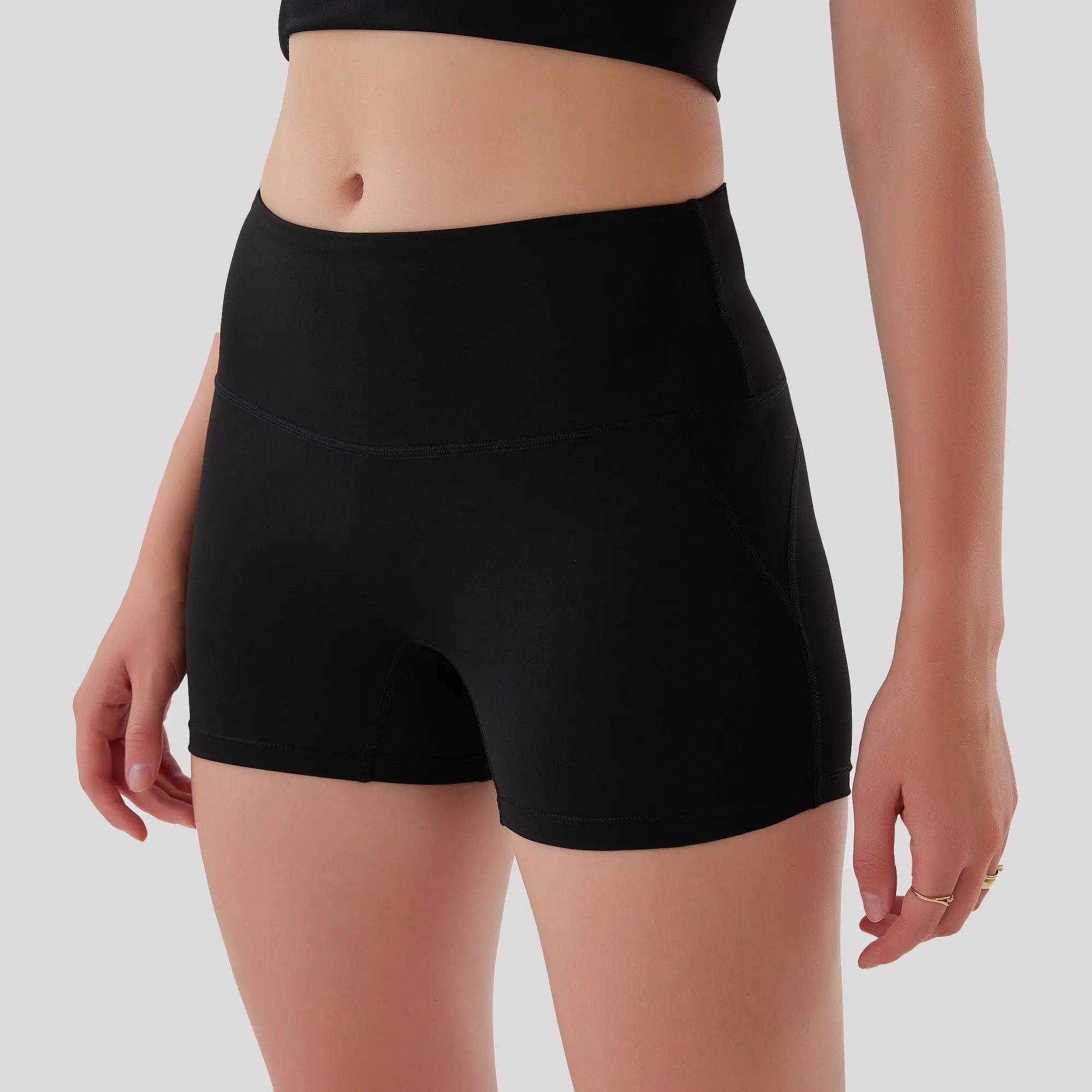 Black high-waisted shorts worn by a person on a plain background