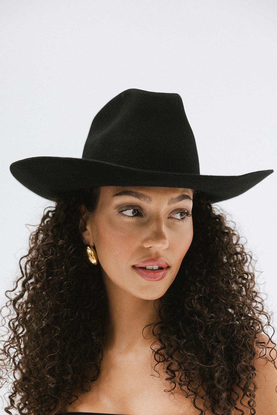 Woman wearing a black hat against a white background