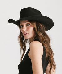 Woman wearing a black hat against a white background
