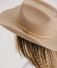 Beige fedora hat with a leather band on a white background